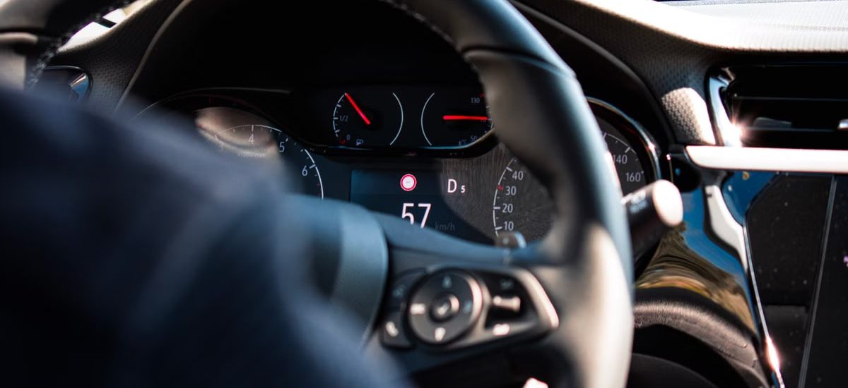 Close-up view of a car dashboard and steering wheel, featuring a digital speedometer display.