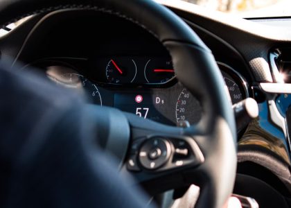 Close-up view of a car dashboard and steering wheel, featuring a digital speedometer display.